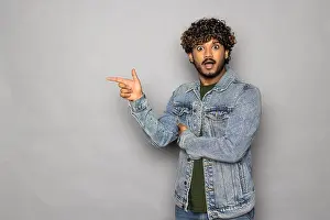 Abroad Prints: Happy indian business man salesman looking pointing fingers hand gesture aside indicating advertising recommending new