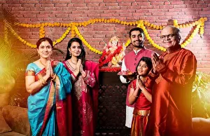 Ganapati Prints: Happy Indian Family Celebrating Ganesh Festival or Chaturthi - Welcoming or performing Pooja