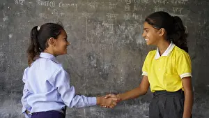 Hygienic Prints: Happy Indian school girl child standing in front of black chalkboard background