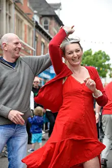 Red Dress Prints: Happy laughing woman wearing a red dress dancing in the streets