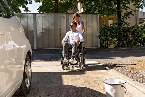 Middle Aged Prints: happy middle aged couple with man sitting on wheelchair washing car at public car wash