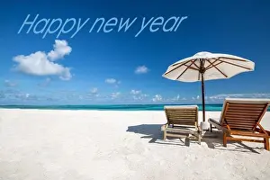 Happy new year written in the sky. Artistic summer beach holiday with new years eve concept