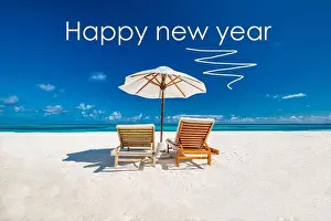 Happy new year written in the sky. Artistic summer beach holiday with new years eve concept