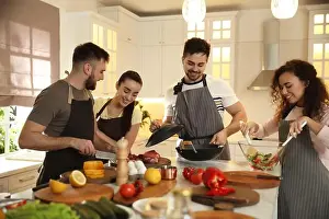 Foodie Prints: Happy people cooking food together in kitchen