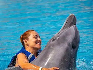 Colombian Prints: An Happy red hair latina girl swimming with a dolphin