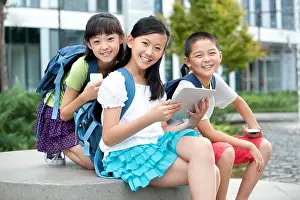 Kneeling Prints: Happy schoolchildren with high-tech digital gadgets