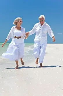 Senior Man Prints: Happy senior man and woman couple running