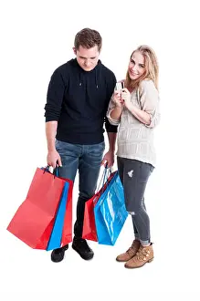 Credit Card Prints: Happy woman holding credit card and sad man carrying bunch of shopping bags isolated on white background