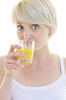 Orange Juice Prints: happy Young blonde woman drinking orange juice isolated over white background