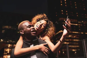 Pleasant Prints: Happy young couple taking selfie at night in the city