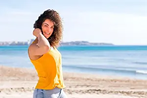 Curly Hair Prints: Happy young curly haired female in yellow top smiling