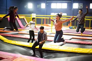 Weekend Activities Prints: Happy young friends jumping on trampoline