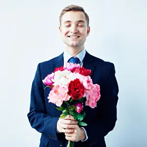 Peony Prints: Happy young man holding bunch of fresh peonies