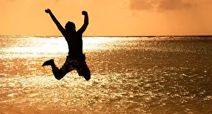 Vocation Prints: Happy Young man jumping on the beach at sunset