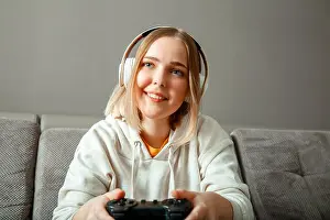 Joystick Prints: Happy young woman player wins in game console while playing video game at home party