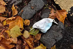 Litter Prints: Hardly used disposable face mask for covid protection thrown away on street as litter, UK