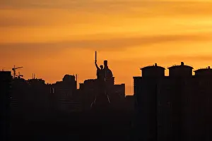 Hazy Prints: A hazy sunset bathes the Kyiv skyline in a warm
