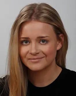 Dyed Prints: headshot or portrait of a young blonde woman with green eyes, wearing a black top