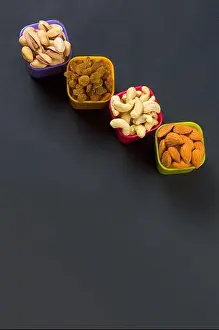 Pistachio Prints: Healthy Mix Dry Fruits and Nuts on dark background. Almonds, Pistachio, Cashews, Raisins