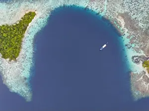 A healthy, robust coral reef surrounds a scenic bay in the Solomon Islands. This beautiful country is home to spectacular marine biodiversity