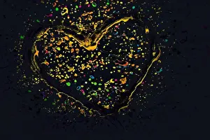 Splatter Prints: Heart on a glass with paint splash effect on it on a black background