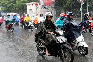 Saigon Prints: Heavy monsoon rain. Vietnamese people driving Motorbikes on Saigon Street