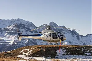Thrilling Prints: Helicopter on a snowy mountain helipad with a picturesque alpine backdrop