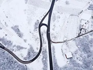 Winter Mountain Prints: High angle top down aerial view drone image on road trough the trees