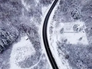Winter Mountain Prints: High angle top down aerial view drone image on road trough the trees