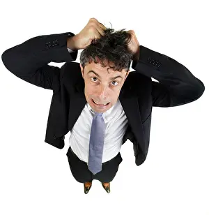 Desperation Prints: High angle fun portrait of a mature business man tearing out his hair in desperation and frustration isolated on white