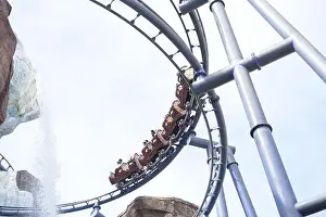 Panic Prints: A high-speed roller coaster loops along steel tracks with riders enjoying the ride