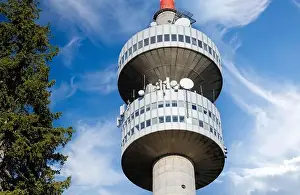 The high tourist observation tower Snezhana on the mountain peak of Snezhana covered with evergreen spruce dense