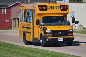 On The Move Prints: Hinckley, Illinois, USA. A small-sized school bus traveling on a U