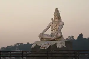 Eyes Closed Prints: Hindu god Shiva statue at Rishikesh, India. River ganga flows in the background