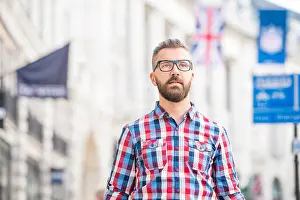 Checked Prints: Hipster man with eyeglasses shopping in streets of London