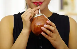 Mate Prints: Hispanic woman drinking mate from traditional cup using metal straw