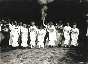 Straw Hat Prints: In this historic image, eight women compete in a hobble skirt race