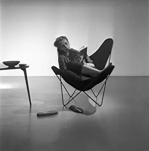 Home Life Prints: Home decor of the 1950s. A young woman is sitting in the popular Butterfly chair