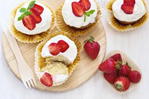 Homemade strawberry cupcakes with whipped cream topping, top view