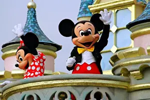 Main Street Prints: Hong Kong, China: Disney stalwarts Mickey and Minnie Mouse riding on a float in the Grand Parade on Main Street