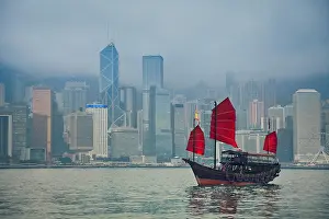 Nostalgia Prints: Hong Kong, China. Hong Kong Junkboat sailing along Hong Kong Skyline on a foggy day