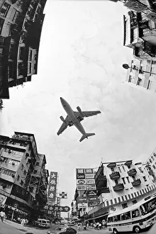 Hong Kong Prints: Hong Kong October 1986 A plane comes approches Kai-Tak airport over the streets of Kowloon