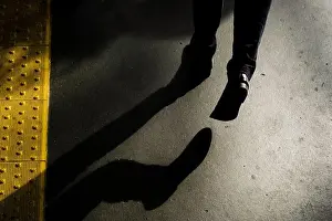 Stone Street Prints: Horizontal shot of a male's shadow walking on the street at night