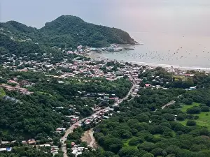 Juan Prints: Houses on main street in San juan Del Sur town aerial drone view