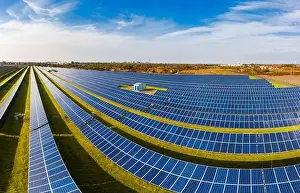 Huge solar power plant to use solar energy in a picturesque green field in Ukraine. Aerial panoramic drone shot