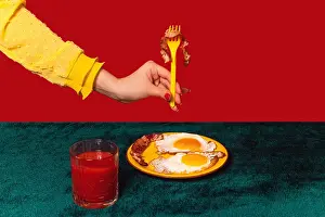 Creativity Prints: Human hand tasting bacon and eggs isolated on green and red background