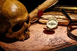 Compass Prints: Human skull with old manuscripts, travel equipment and world map on black background