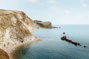From above idyllic seascape with rocks called Durdle Door and people relaxing on seashore on summer day