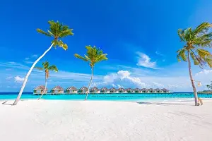 Idyllic tropical beach landscape with water villas and bungalows. Design of tourism summer vacation holiday destination concept. Luxury island beach