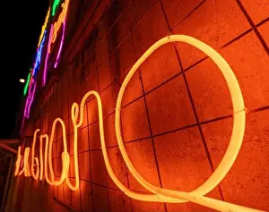 Cyberpunk Prints: Illuminated letters and words made with neon lights and LEDs of many colors with a vanishing point in the background